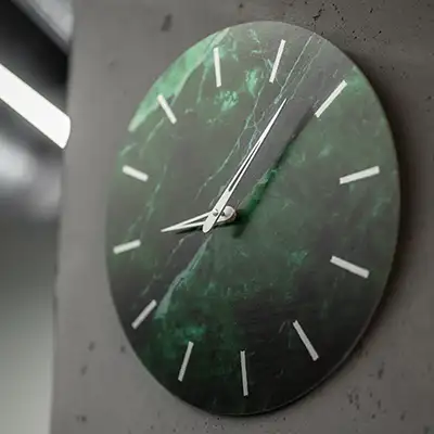 Moderne grüne Uhr auf Betonwand im Friseurladen